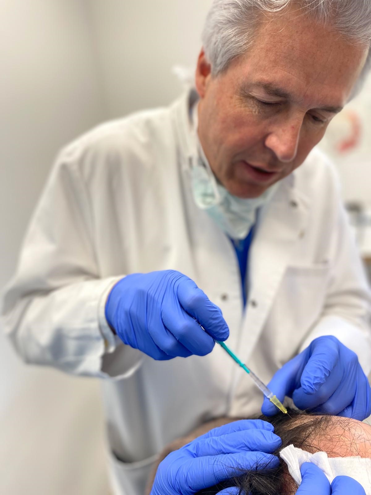 Prof. Dr. Ockenfels injiziert Stammzellen in die Kopfhaut im Rahmen einer Therapie zur Haarverpflanzung.